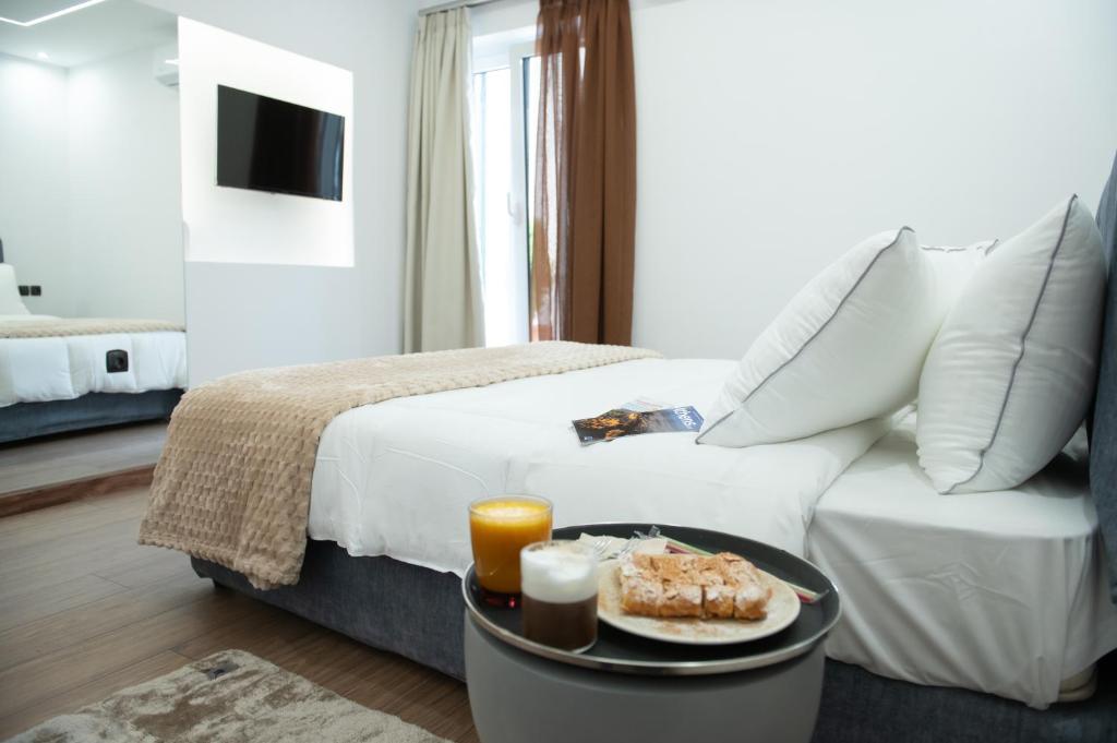 a hotel room with a bed and a table with food on it at Klitiou 7 Boutique Hotel in Athens