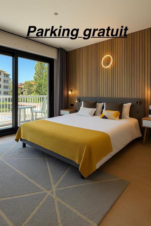 a bedroom with a large bed with a yellow blanket at Savoie Hotel aux portes de Genève in Saint-Julien-en-Genevois