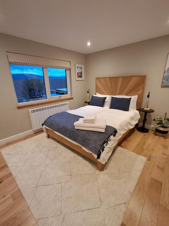 a bedroom with a large bed and two windows at An Sealladh in Fort William