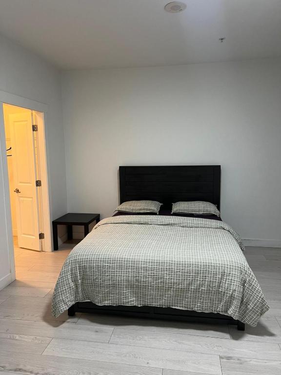 a bedroom with a large bed with a black headboard at 2 Bedroom plus den 2 Bathroom apartment in Surrey