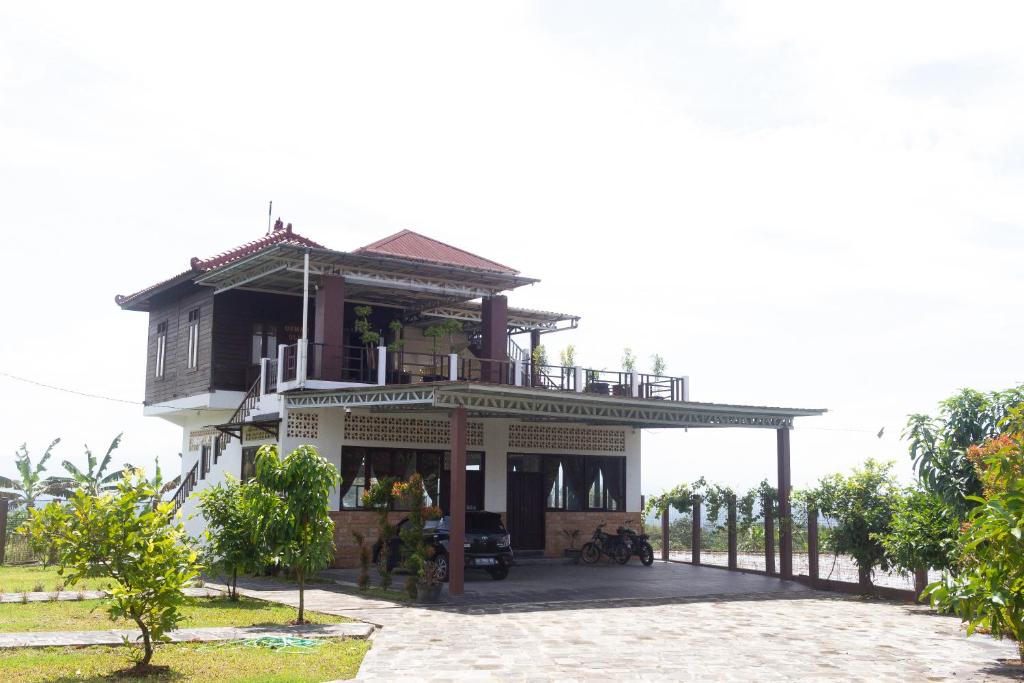 an old house on the beach with the ocean in the background at Omah Ulin in Bandongan