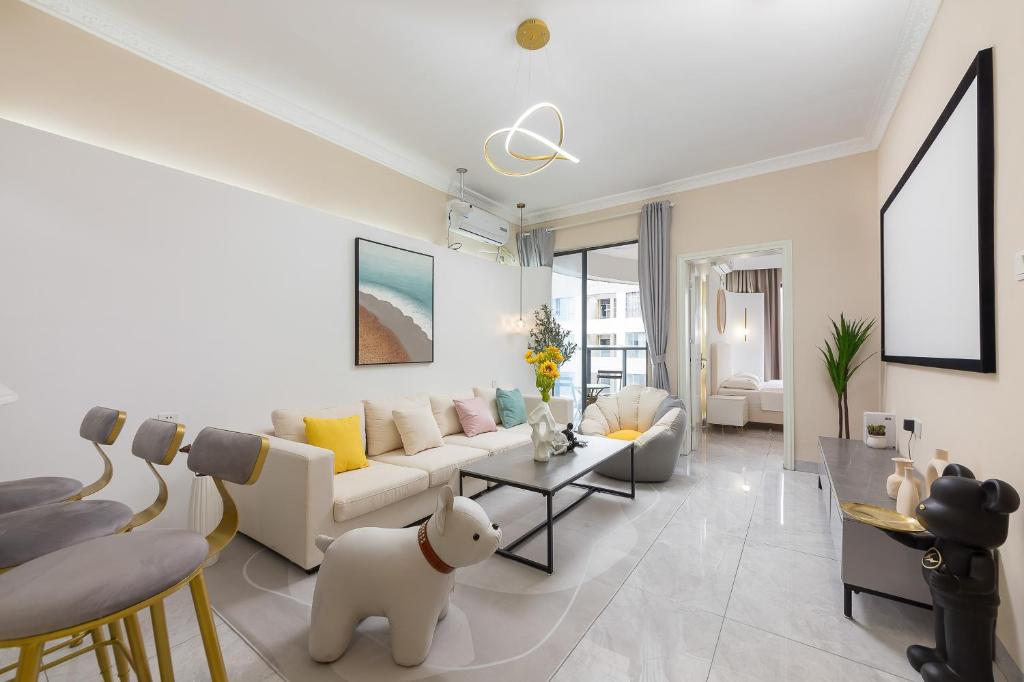 a living room with a white couch and a table at Sanya Lili B&B in Sanya