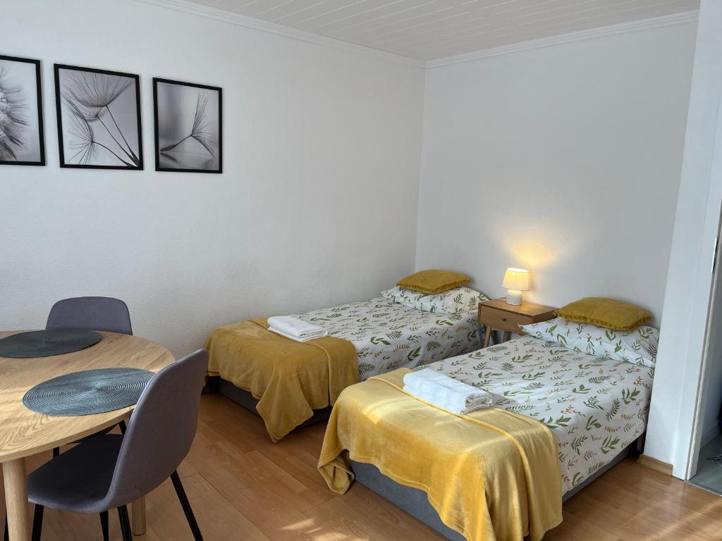 a room with two beds and a table and chairs at Apartament Korczaka możliwość wystawiania Faktur, WI-FI in Suwałki
