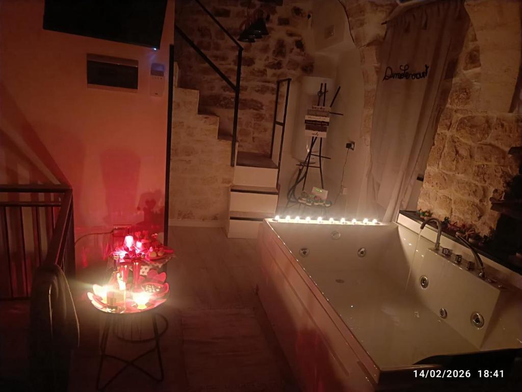 a room with a tub and a table with lights at Dimore Levante Borgobianco in Turi