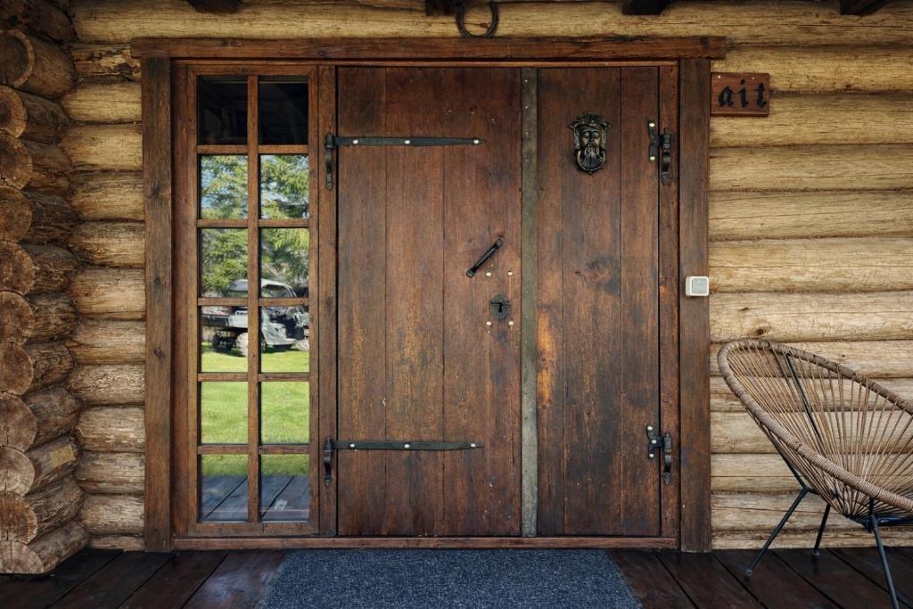 a wooden door on the side of a log cabin at Sepasauna holiday house in Joaveski