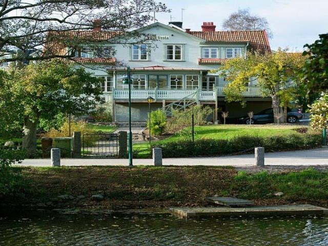 uma grande casa branca sentada ao lado de um lago em Hotell Villa Vesta em Ronneby