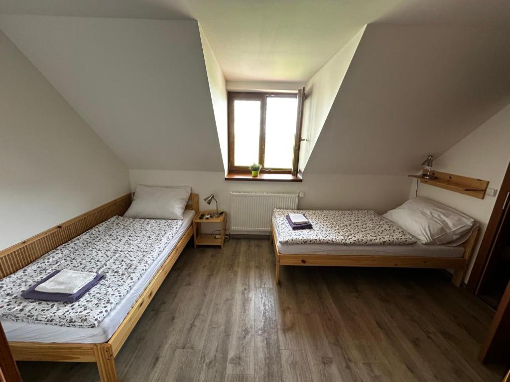 two beds in a room with a window at Penzion U Ježka in Nedakonitz