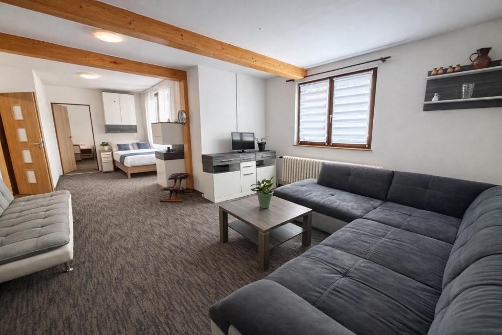 a living room with a couch and a table at Prášily 100 - apartmány in Prášily