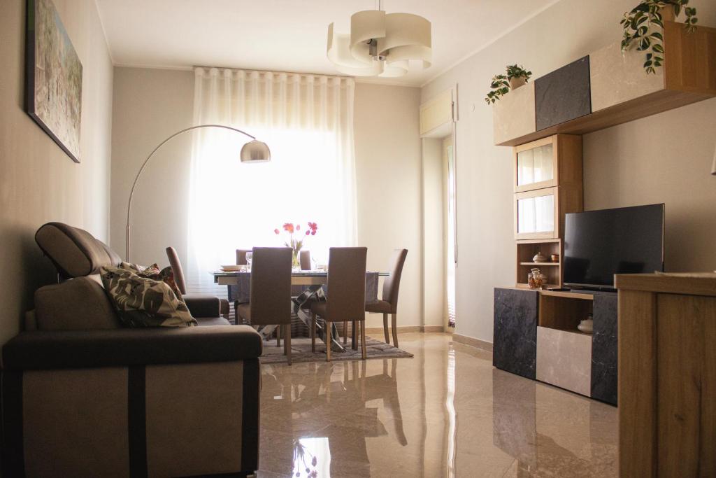 a living room with a table and a dining room at vivaldi casa vacanza in Caserta