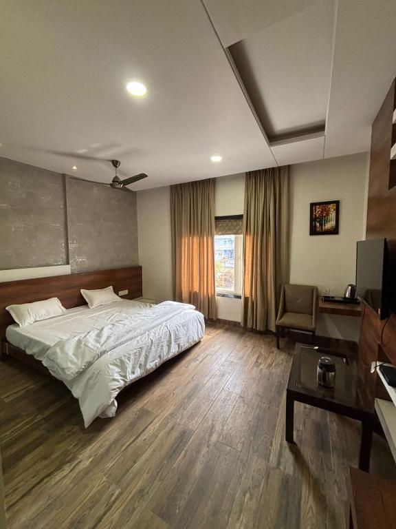 a bedroom with a large bed and a television at Hotel Singh Empire in Sāgar