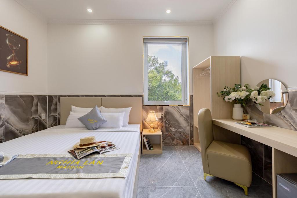 a bedroom with a bed and a desk and a window at Nghia Lan Maison - DL Center in Da Lat