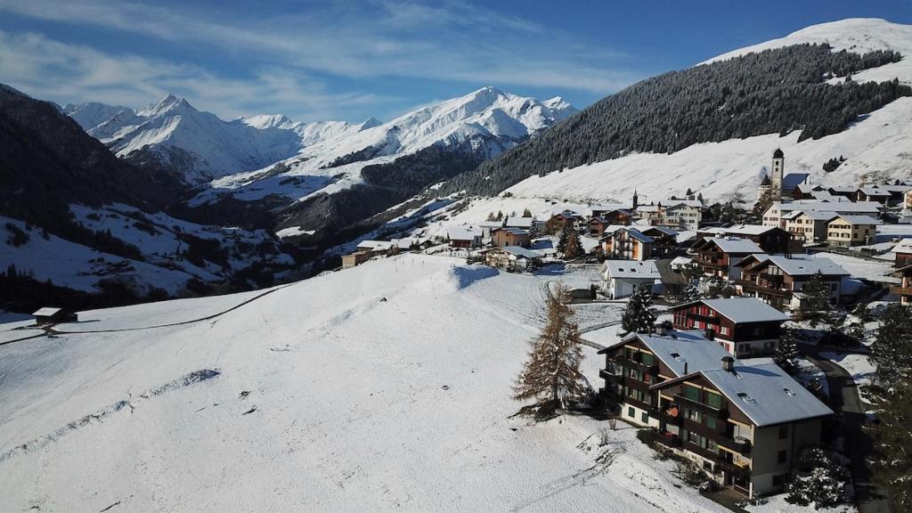 a town on top of a snow covered mountain at Family-friendly apartement in Lumbrein