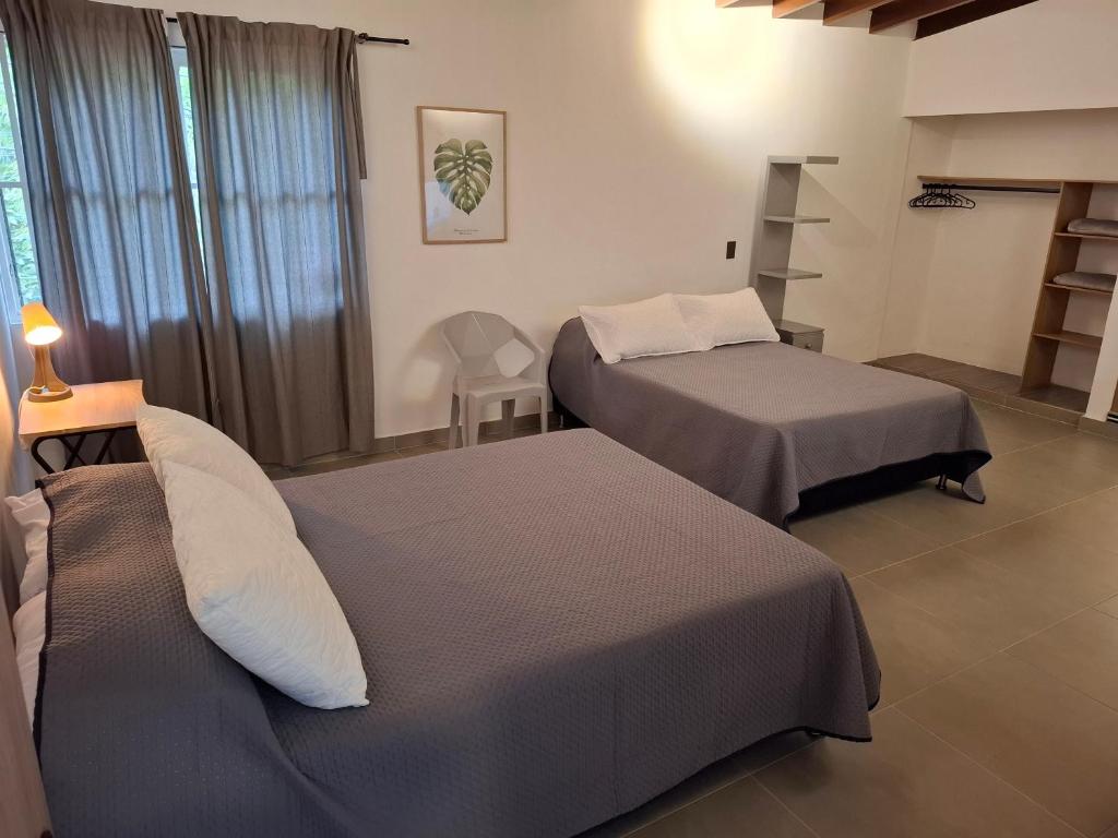 a room with two beds and a shelf at Hotel La Casona - Cerca al Estadio Atanasio Girardot y Laureles in Medellín