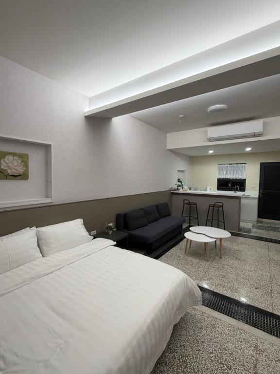 a bedroom with a large bed and a living room at 簃居青衖 in Tainan