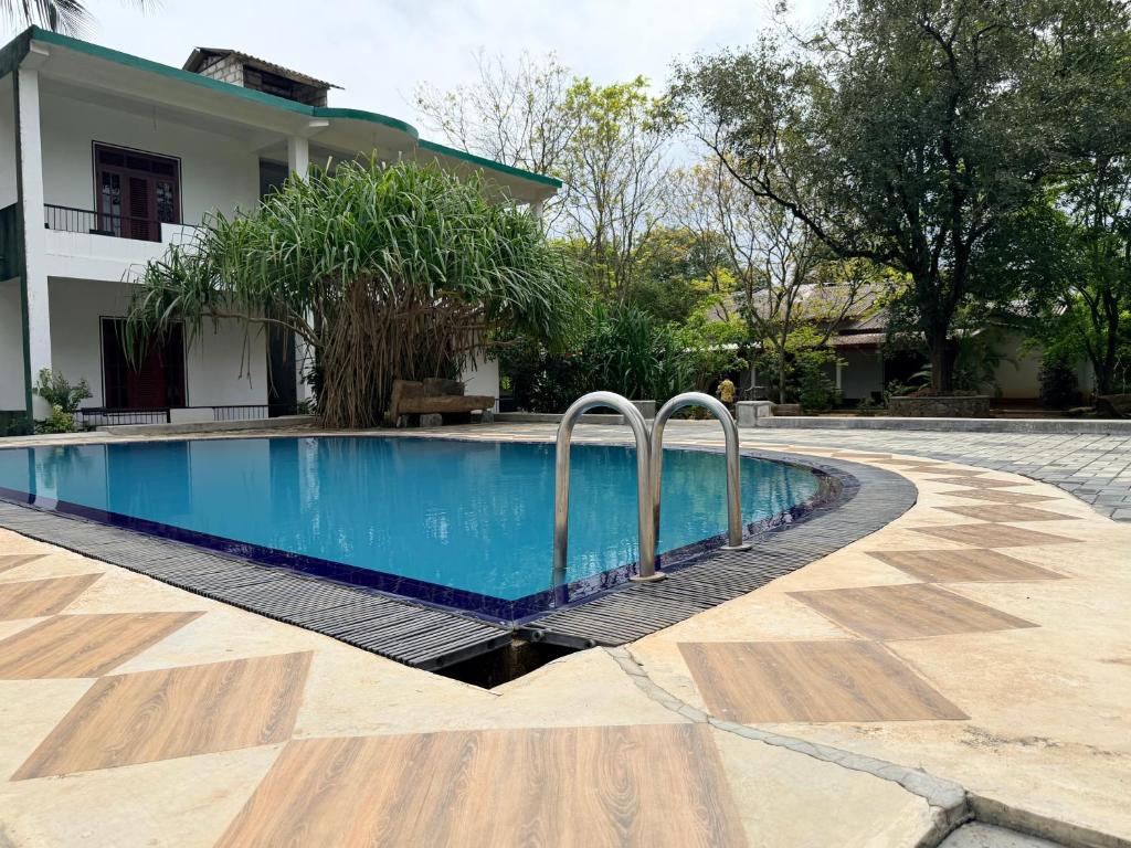 a swimming pool in front of a house at Royal Garden in Dambulla