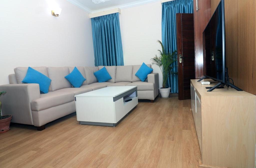 a living room with a couch and a tv at New apartment in Hattigauda in Khadkagaon