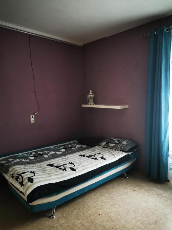 a bed in a room with a purple wall at Stadtmitte Ferienwohnung in Darmstadt