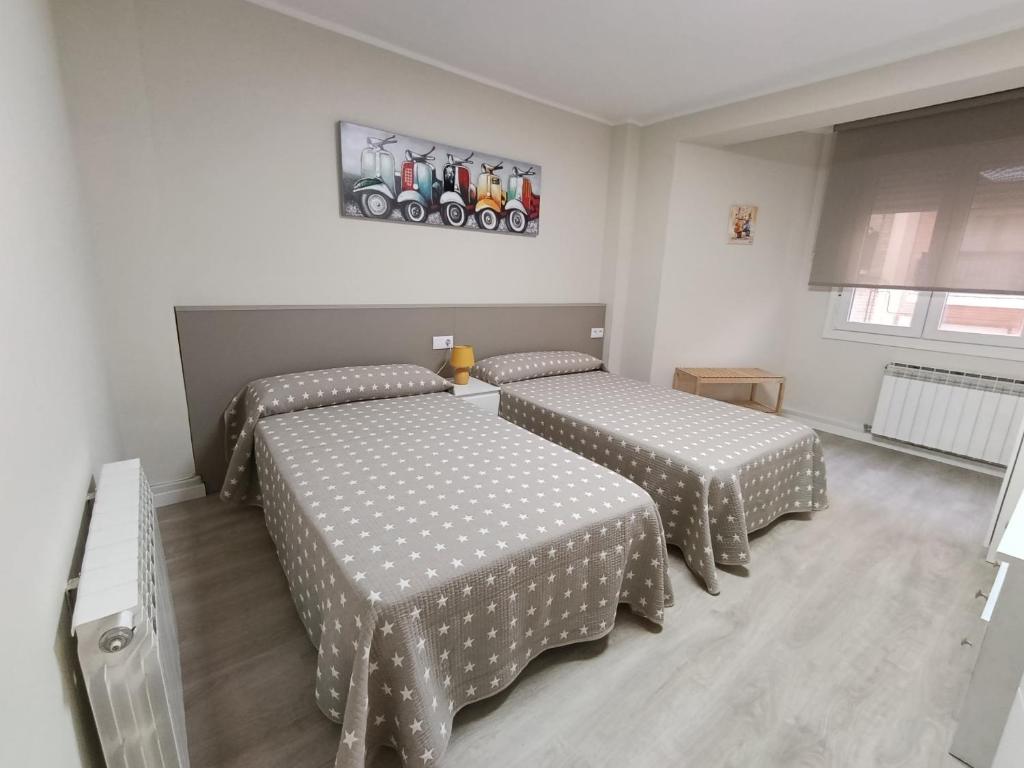 a bedroom with two beds with polka dot sheets at VUT Montse in Alcañiz