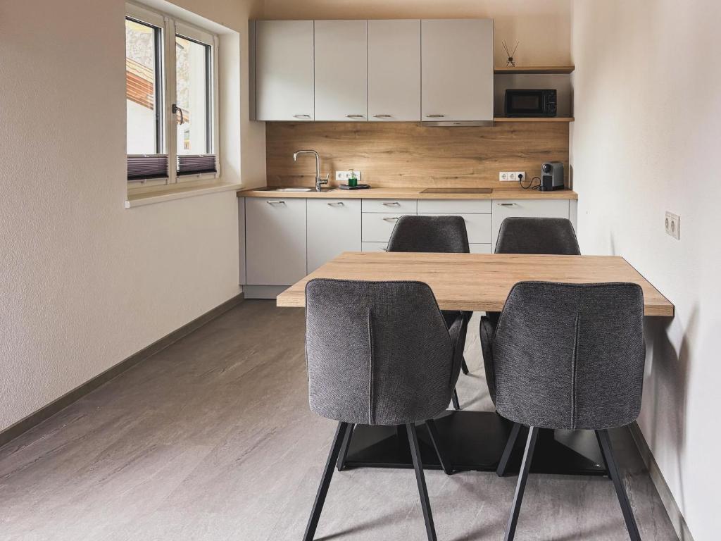 a kitchen with a wooden table and four chairs at 6444 Apartment in Unterlängenfeld