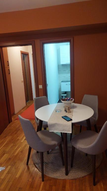 a dining room with a white table and chairs at Stan na dan DM Uzice in Užice