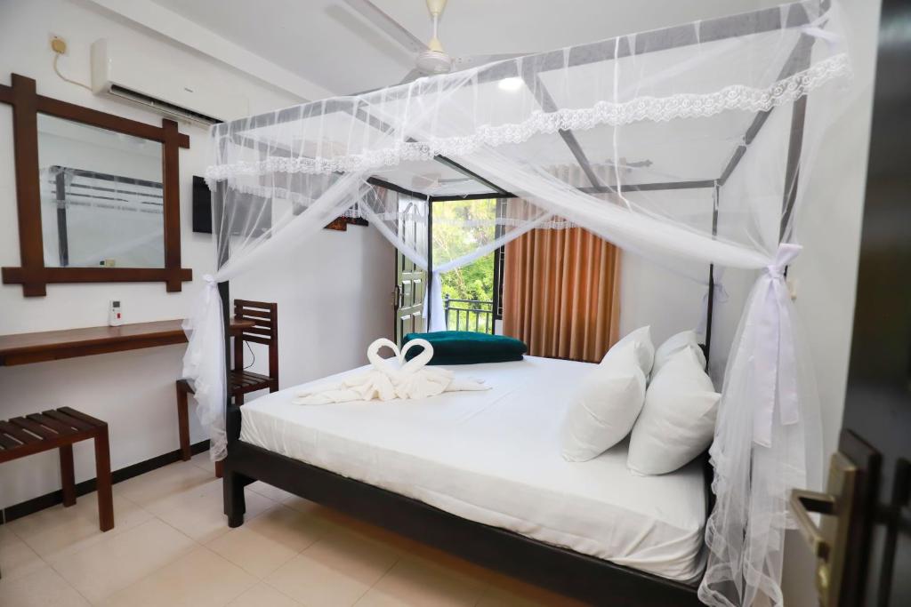 a bedroom with a bed with a canopy at Yala Elegant Hotel in Tissamaharama