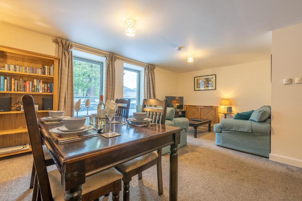 a dining room with a table and a couch at Torr Apartment Raven in Fort Augustus
