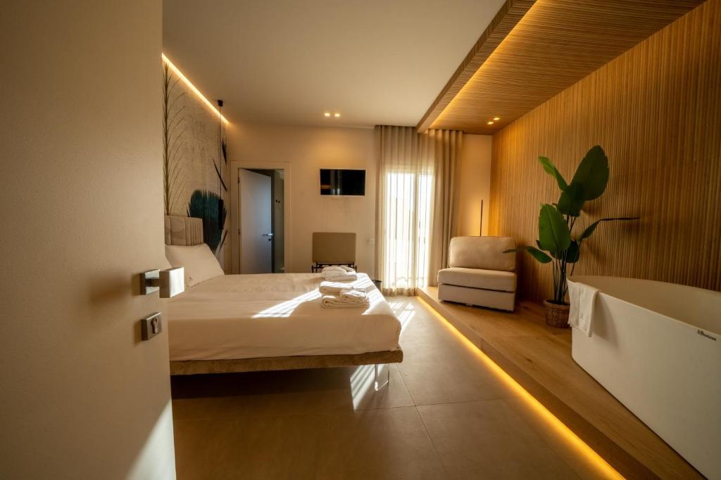 a bedroom with a bed and a couch in a room at Agorà Luxury Experience in Zafferana Etnea