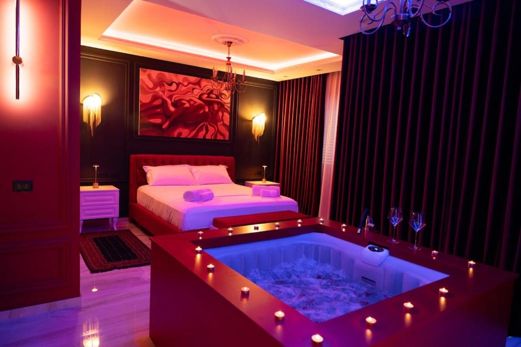 a bedroom with a tub with a bed and a bed and a bed at Luxury Love Suites in Elbasan