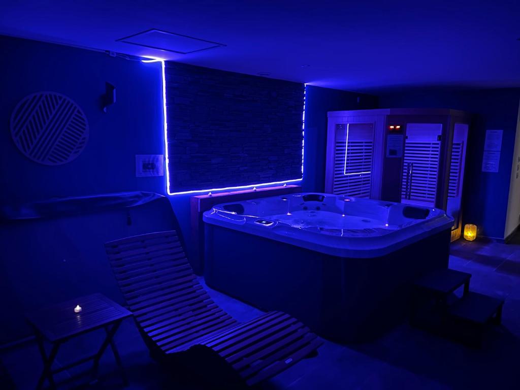 a dark room with a tub and a table and chairs at Evad&vous in Recquignies