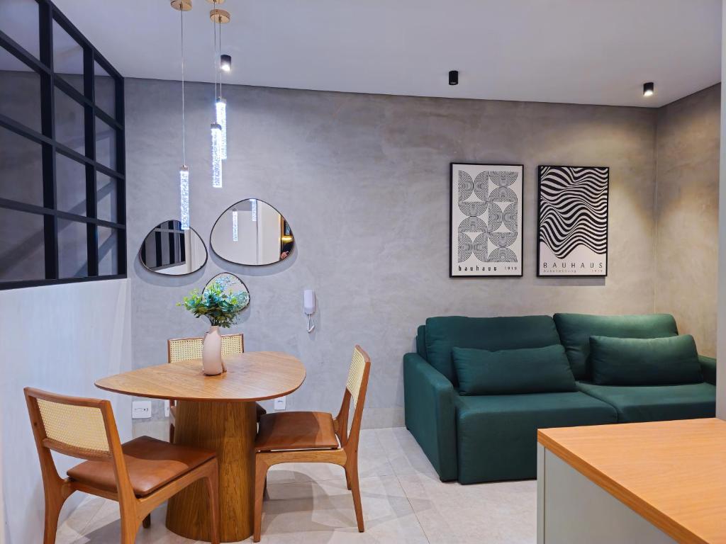 a living room with a table and a green couch at Apartamento Loft 02 Lazer Completo in Belo Horizonte