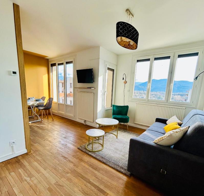 a living room with a couch and a table at Appartement Bellevue - T2 vue montagne - calme - parking gratuit - 4 personnes in Meylan