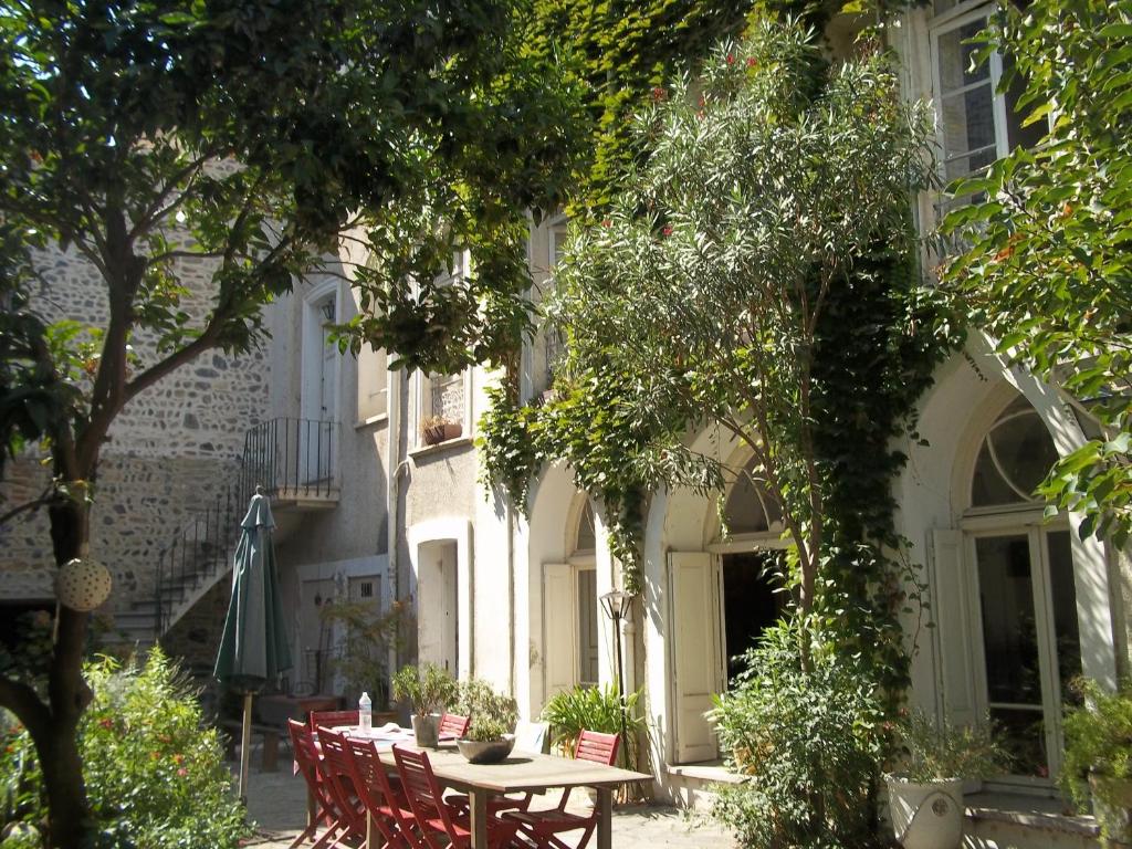 a table and chairs in front of a building at L'Orangerie in Rivesaltes