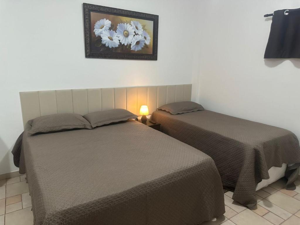two beds sitting next to each other in a room at Kitnet no interior de São Paulo 22 in Serra Negra