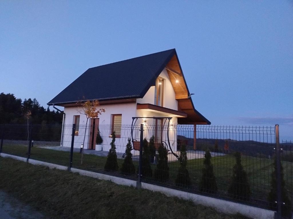 a small white house with a black roof at Domek Na Klinie in Jastrzębia