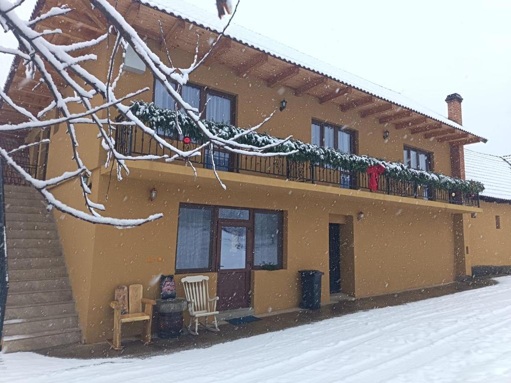 a house with a balcony in the snow at Mountain Breeze in Borlova