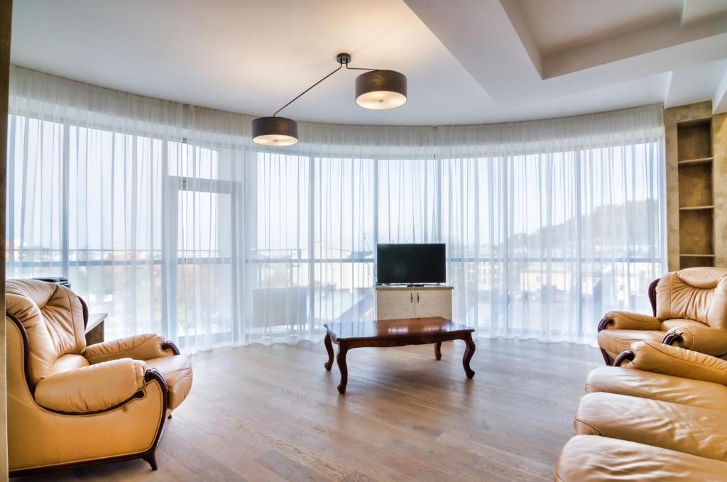 uma sala de estar com duas cadeiras e uma televisão em LEOGRAND Apartments z Panoramoyu Lvova em Lviv
