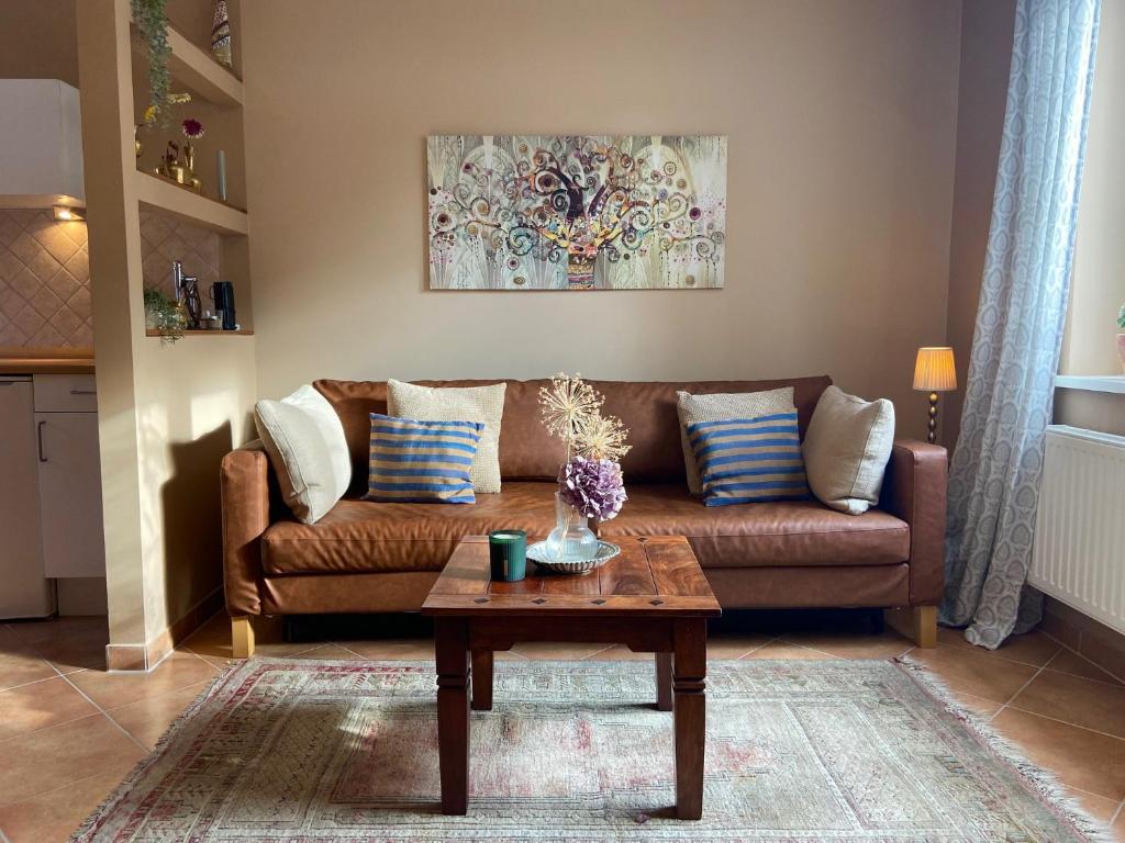 a living room with a brown couch and a coffee table at Ferienwohnung an der Schlei in Fleckeby