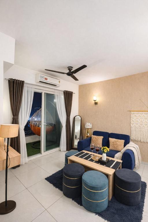 a living room with a blue couch and a table at Warm Embrace in Noida