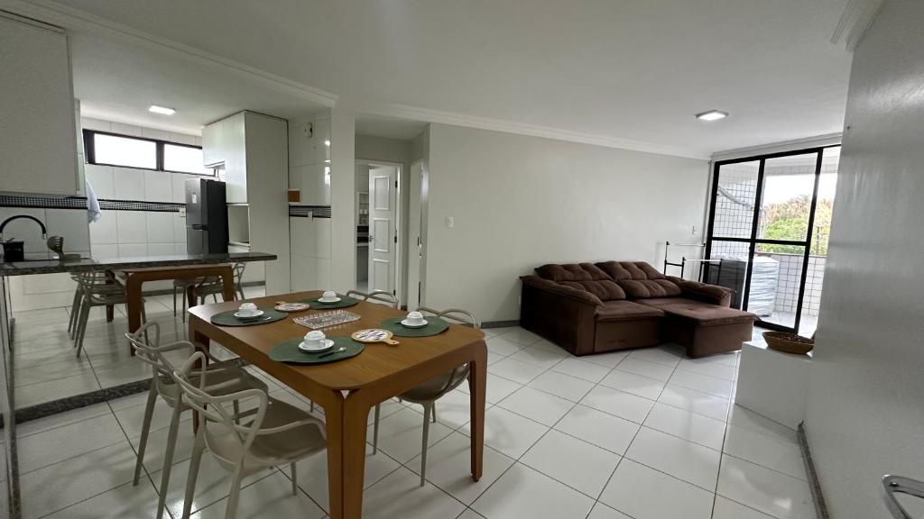 a kitchen and living room with a table and a couch at Beach Garden Ap lagoa Serena in São Luís