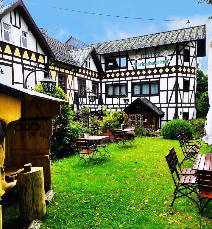 a large building with tables and chairs in a yard at Landhotel Marienthaler Hof in Marienthal