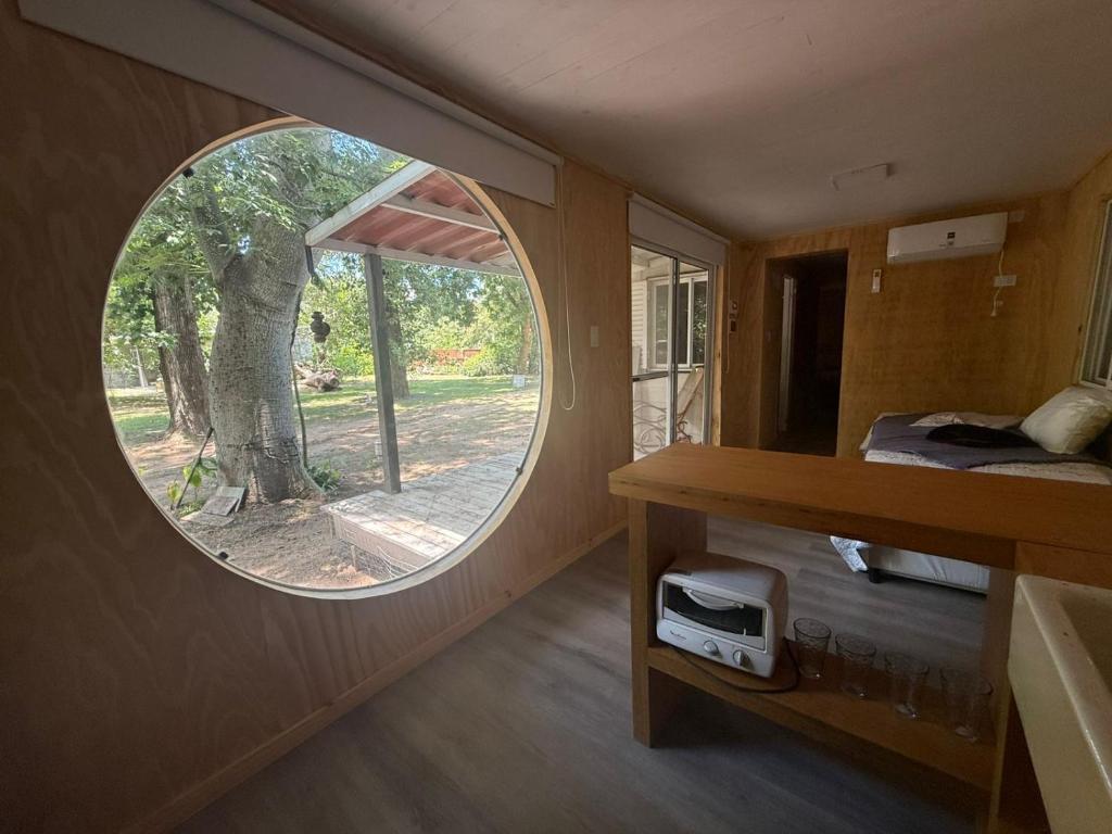 a round window in a small room with a tree at Resolana y Rinconada in Isla del Rincón