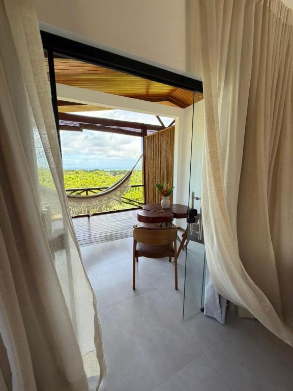 a room with a table and a window with a view at Pousada Almaré Boipeba in Ilha de Boipeba