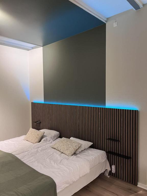 a bedroom with a bed with a blue accent wall at Møn Klintholm Vintage B&B in Borre