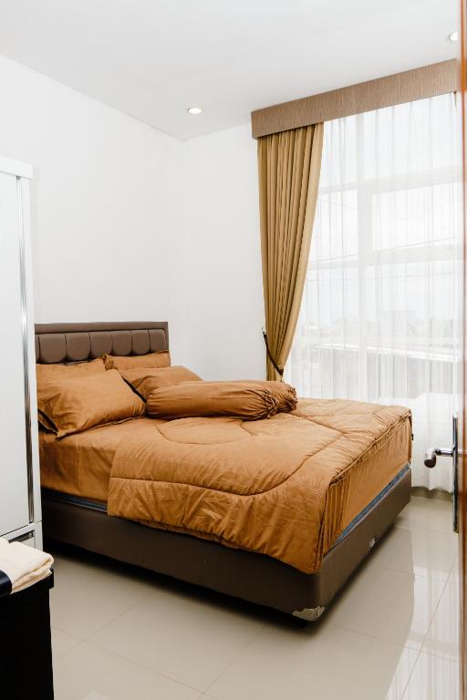 a bed in a white room with a window at Haus Strahlende Villa in Batu