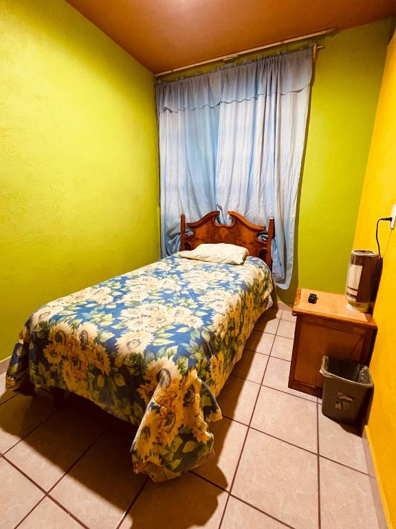 a small bedroom with a bed and a window at Casa Dos Arbolitos in Ciudad Nezahualcóyotl