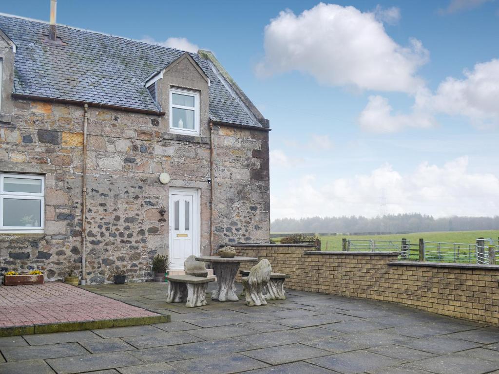 a patio with two benches and a table in front of a building at West Tannacrieff in Stewarton