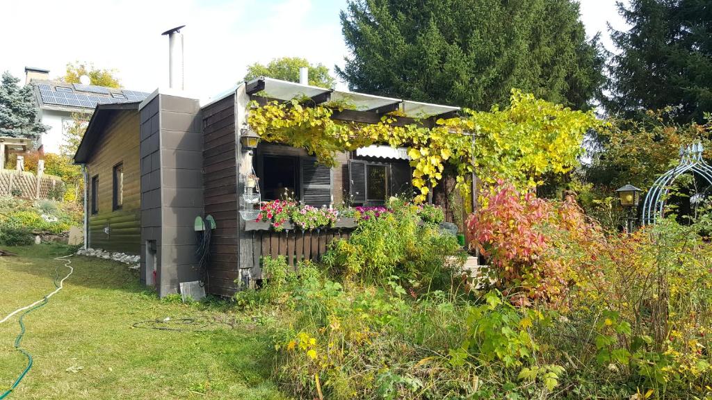 um jardim com uma casa com um ramo de flores em Gemütliches Ferienhaus mit grossem Garten, ideal für Naturliebhaber em Gerhardshofen