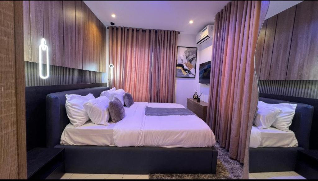a bedroom with a bed with white sheets and pillows at Luxury 3Bedroom Apartment in Sangotedo Ajah in Lekki