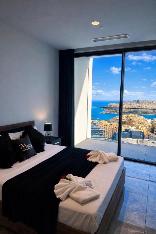 a bedroom with a bed with a view of the ocean at Whispering Waves at Mercury Tower with panoramic view , 2X pools and Gym in Paceville