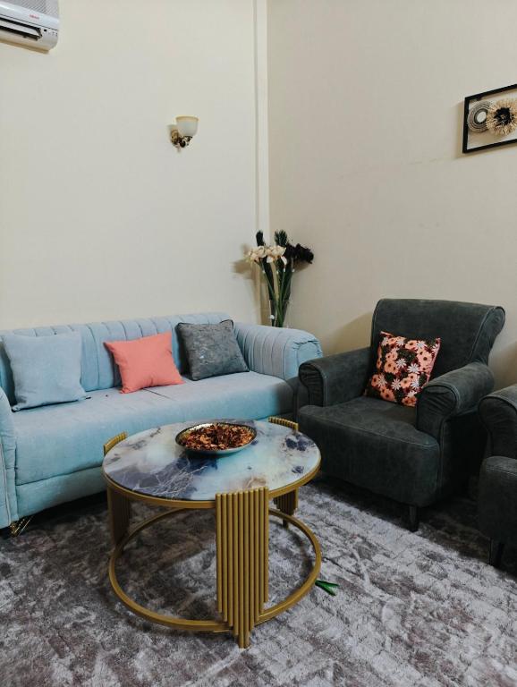 a living room with a blue couch and a table at Tataicha Appart 3 in NʼDjamena